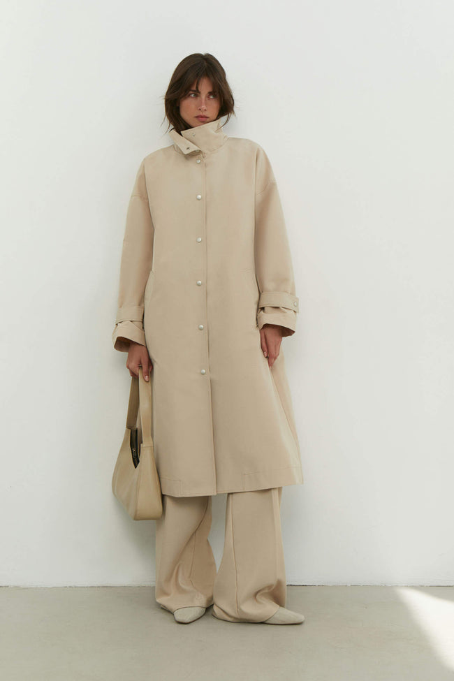 Trenchcoat with a free cut in cream/black